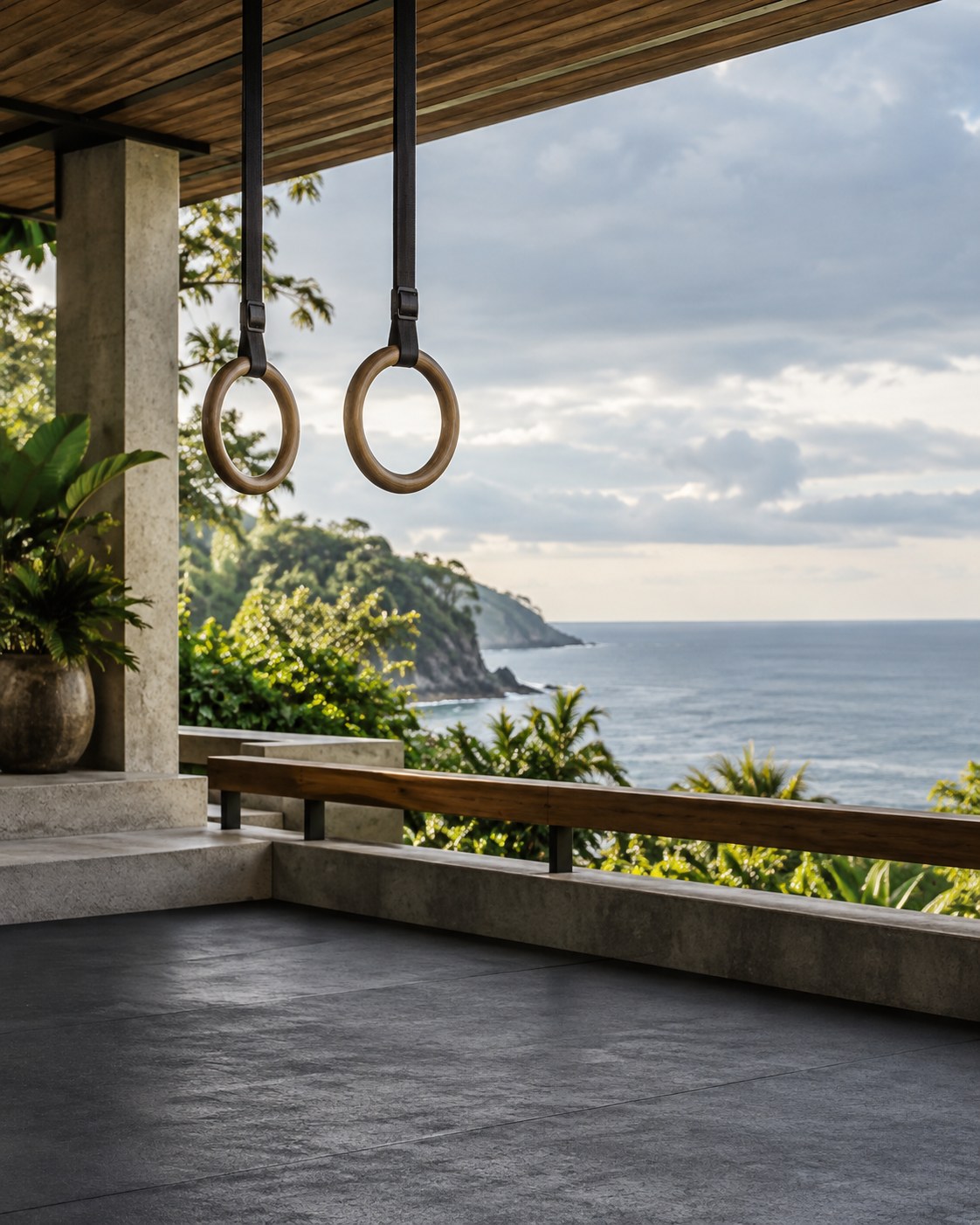 Illustrative scene: Wooden training rings above an empty open-air fitness deck overlooking the coast.